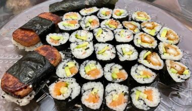 Sushi platter with salmon roll, tempura shrimp roll, california roll, spam musubi, and failed hand roll