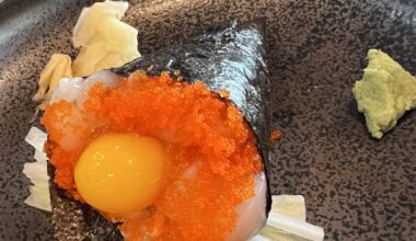 Scallop handroll with tobiko and raw quail egg.