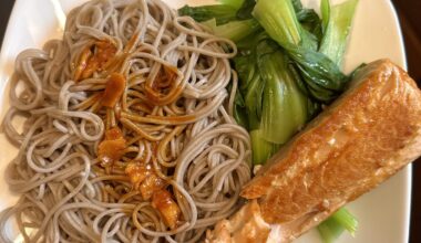 Soba noodles with sauce, seared salmon, and baby bok choy.