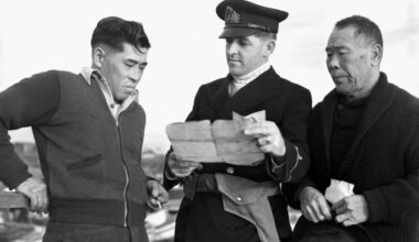 A Royal Canadian Navy officer questions Japanese-Canadian fishermen while confiscating their boat. Canada confiscated thousands of fishing boats from Japanese-Canadians when they were put into internment. They were never compensated.