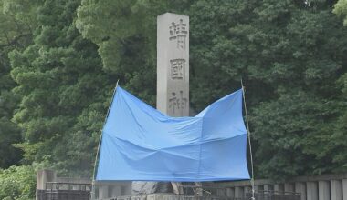 Graffiti on a stone pillar at Yasukuni Shrine, red sprayed in English meaning 'toilet'