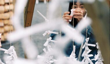 A young girl tie up an Omikuji fortune slip at Hokkaido Jingu shrine in Sapporo