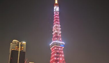 Tokyo Tower, glowing radiantly in the heart of the city, lighting up the night sky